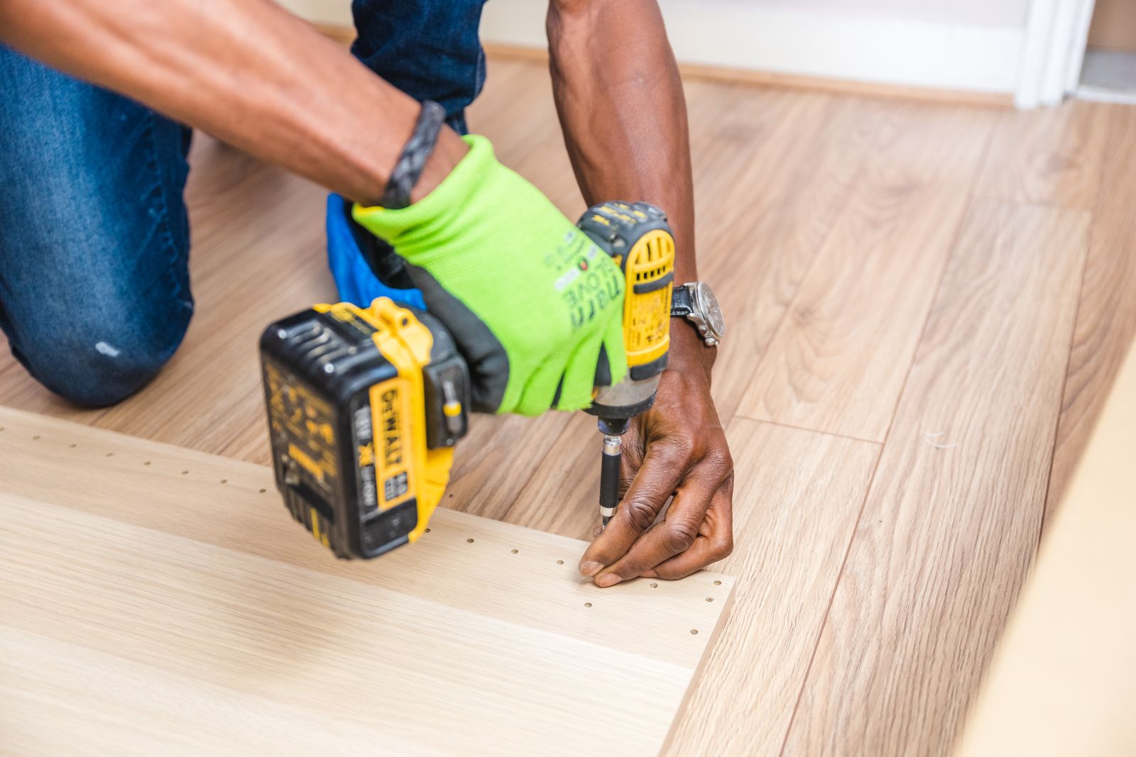 Person holding a yellow and black DeWalt cordless drill