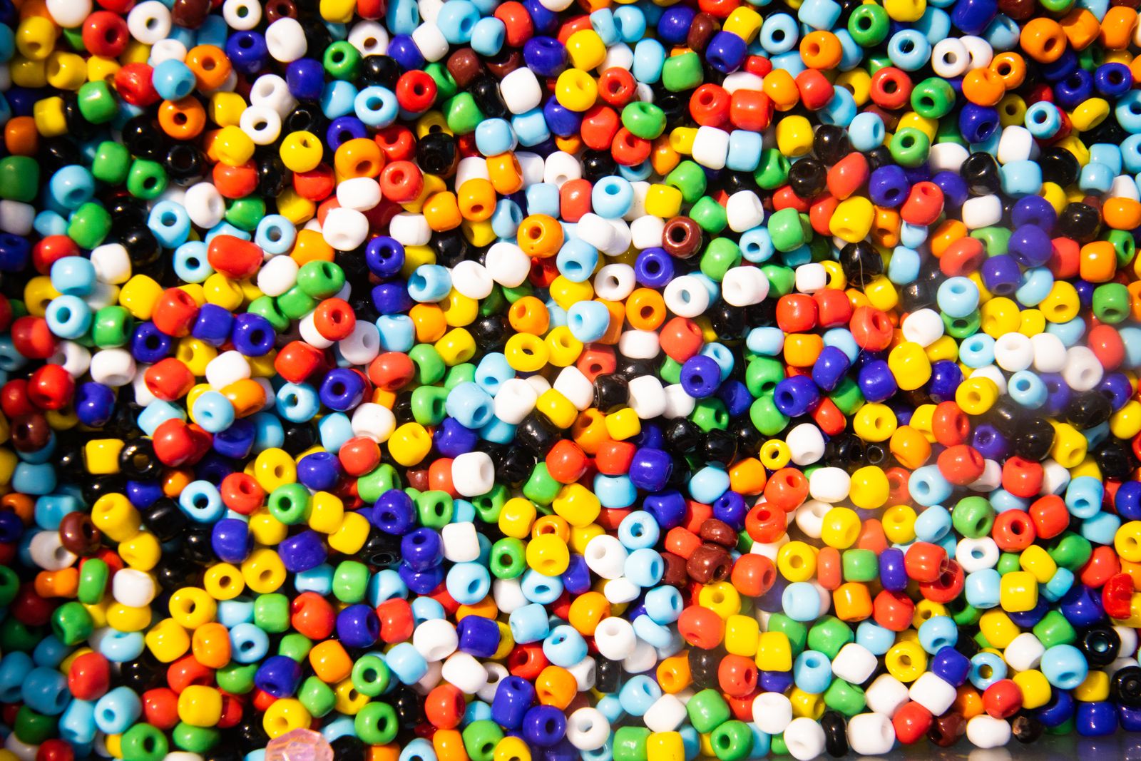 Assorted colorful craft beads and rhinestones sorted by color, similar to diamond painting drills