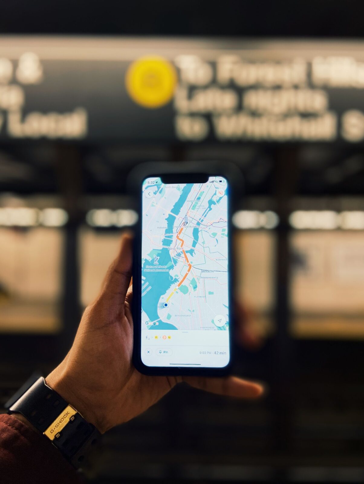 Person holding a smartphone showing a map on the screen while traveling