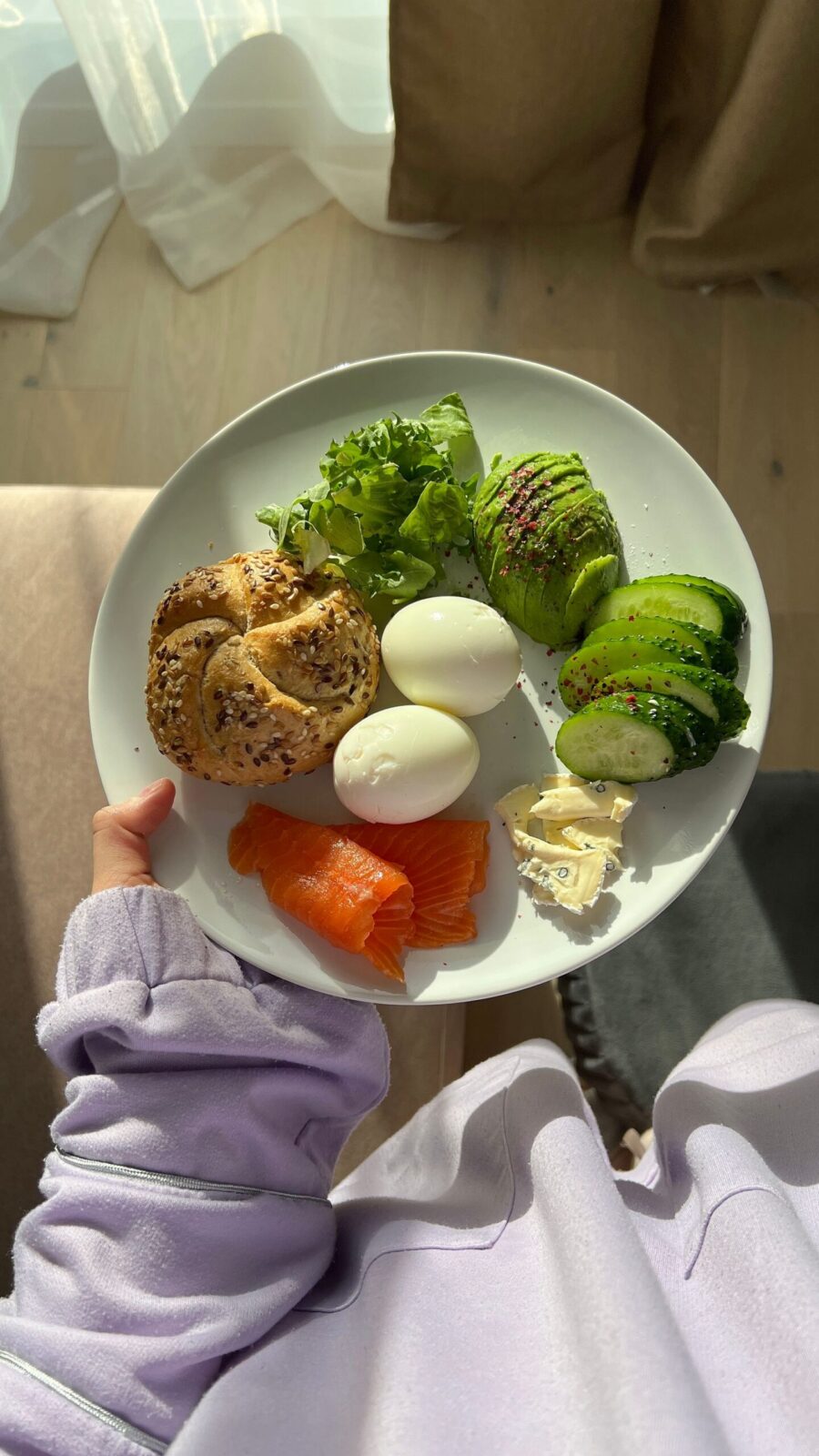 Hand holding a plate with a protein-forward breakfast