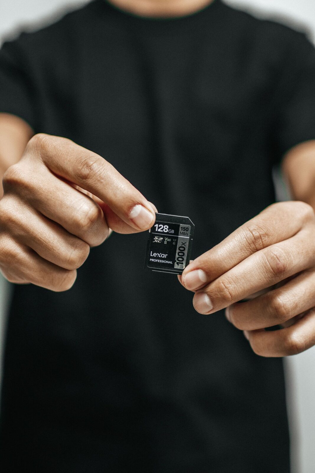A microSD memory card held next to a compact dash cam