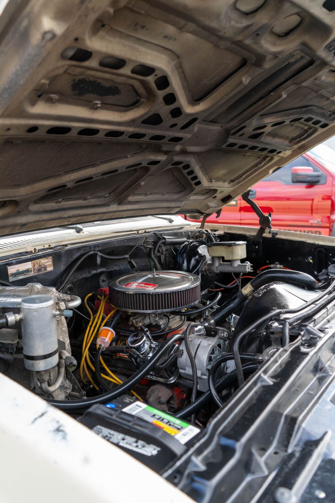 Open car hood showing the engine bay where jump-starter clamps connect