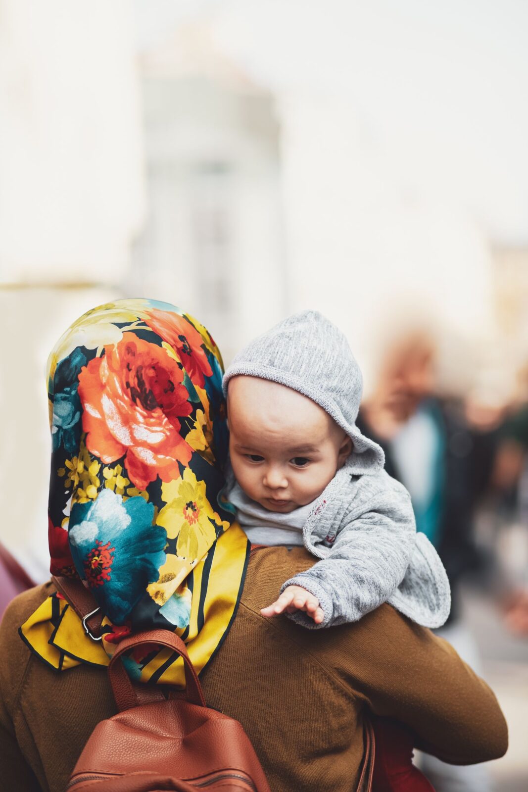 Parent carrying a baby while walking outdoors