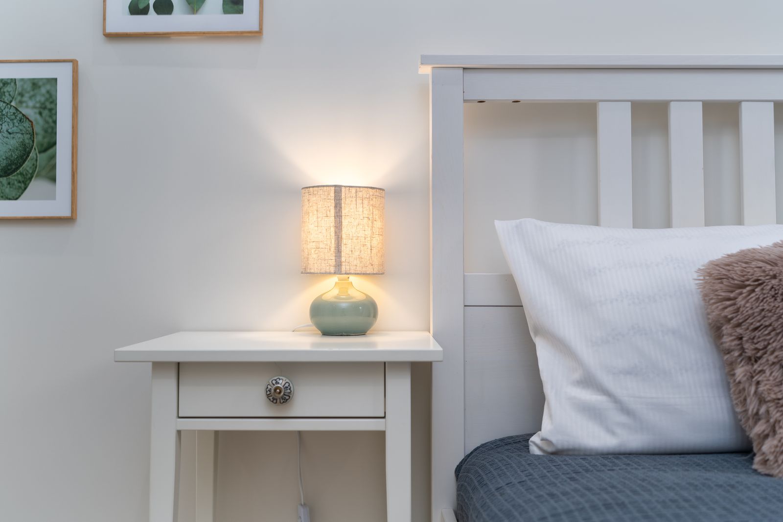 Cozy bedroom scene with a warm nightstand lamp beside the bed