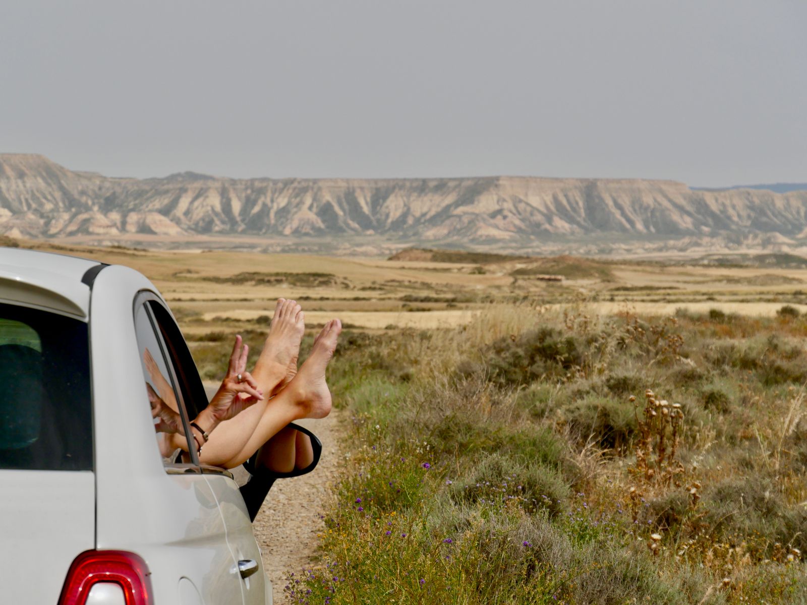 A car on an open scenic desert road on a long road trip