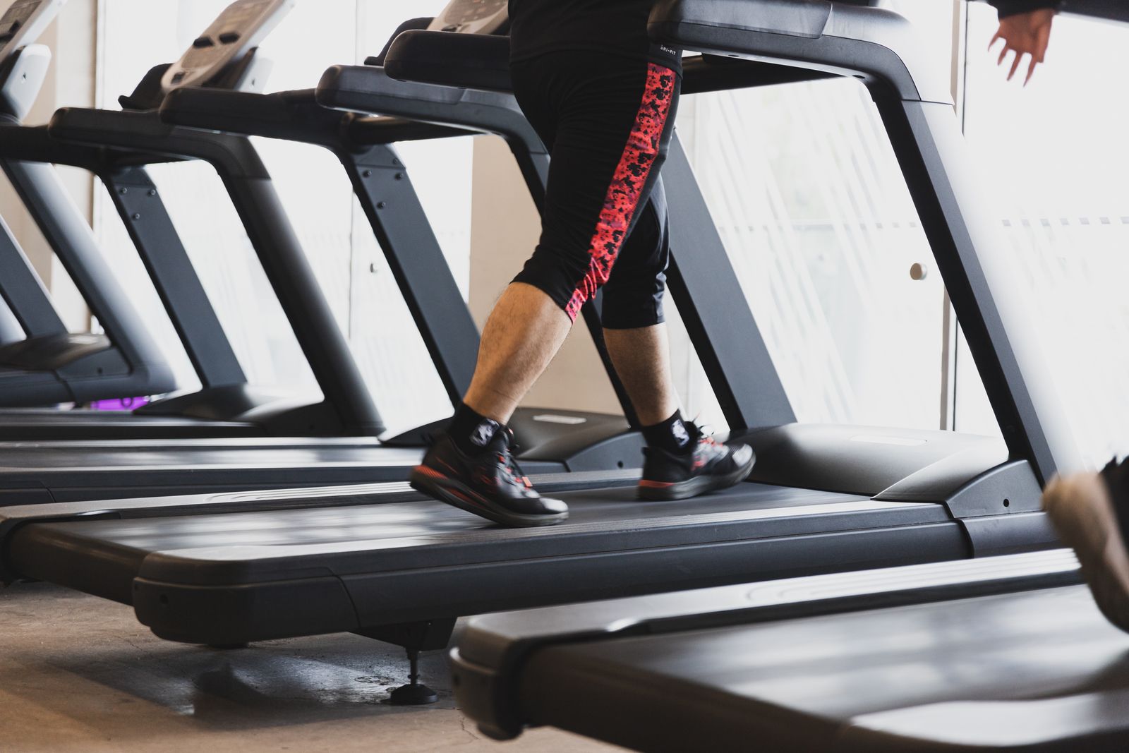 A person walking on a treadmill belt at a steady pace