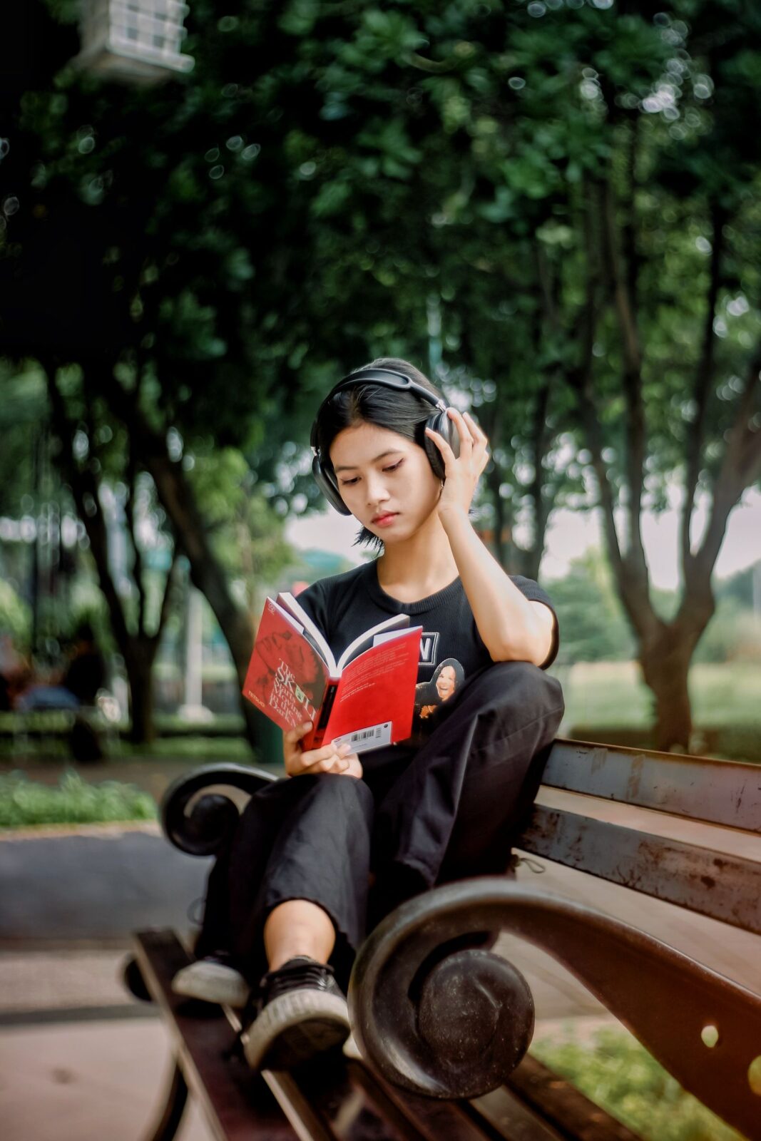 Young woman reading outdoors on a park bench