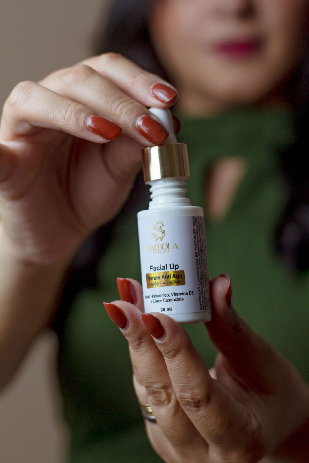 Close-up of a person applying a few drops of facial serum from a dropper bottle