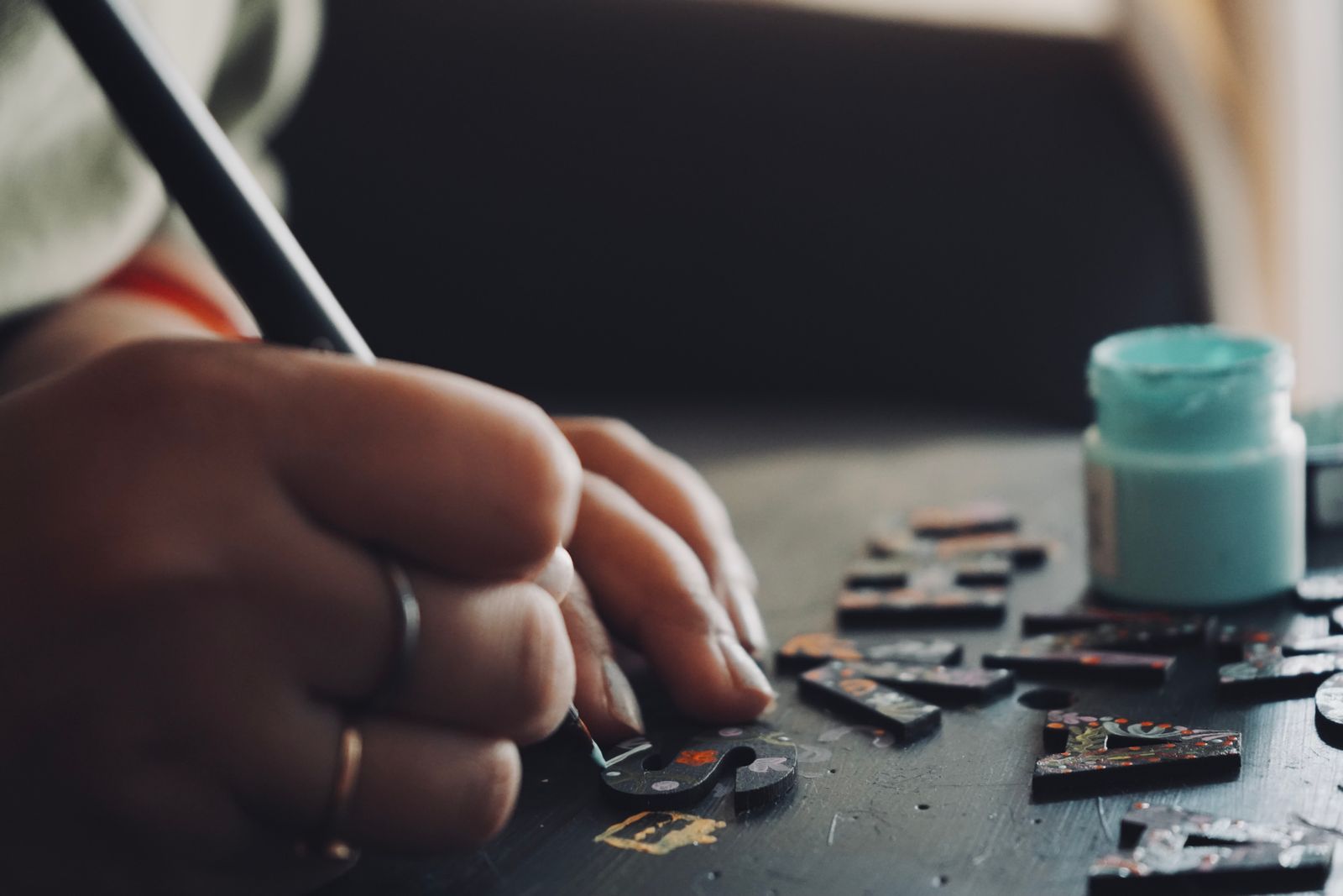 Close-up of a hand carefully placing small craft pieces during a detailed hobby project