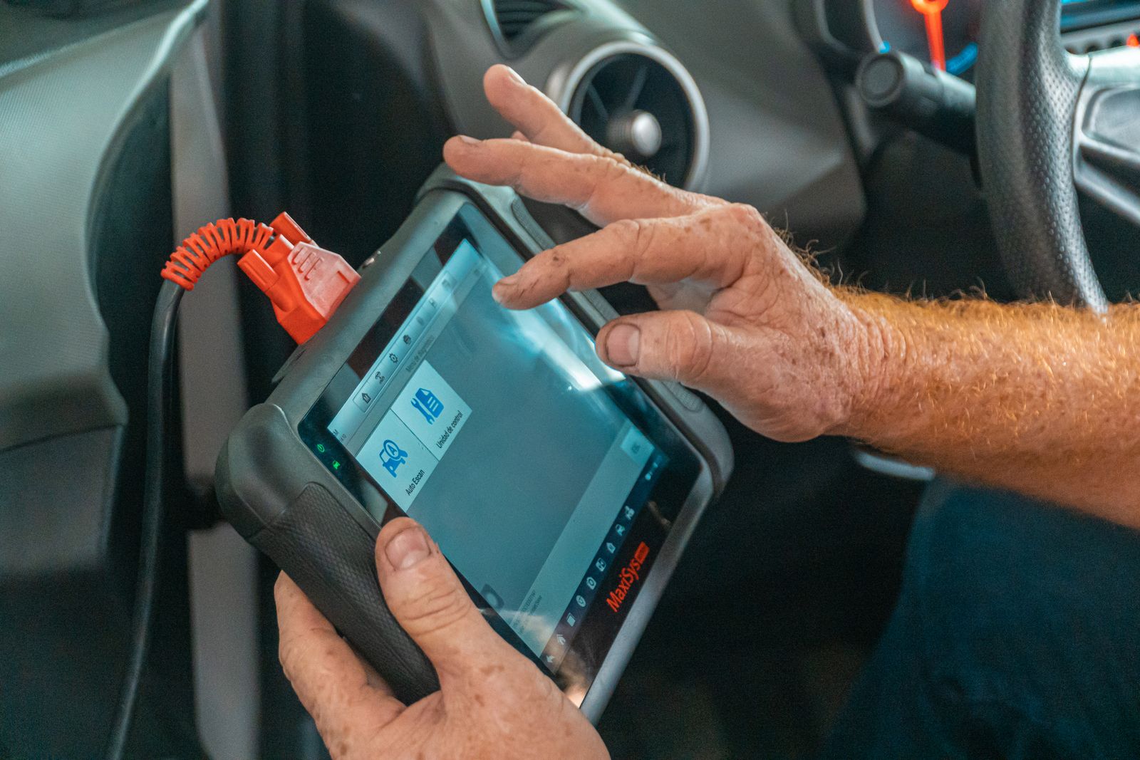 Person holding a handheld automotive diagnostic scanner tool