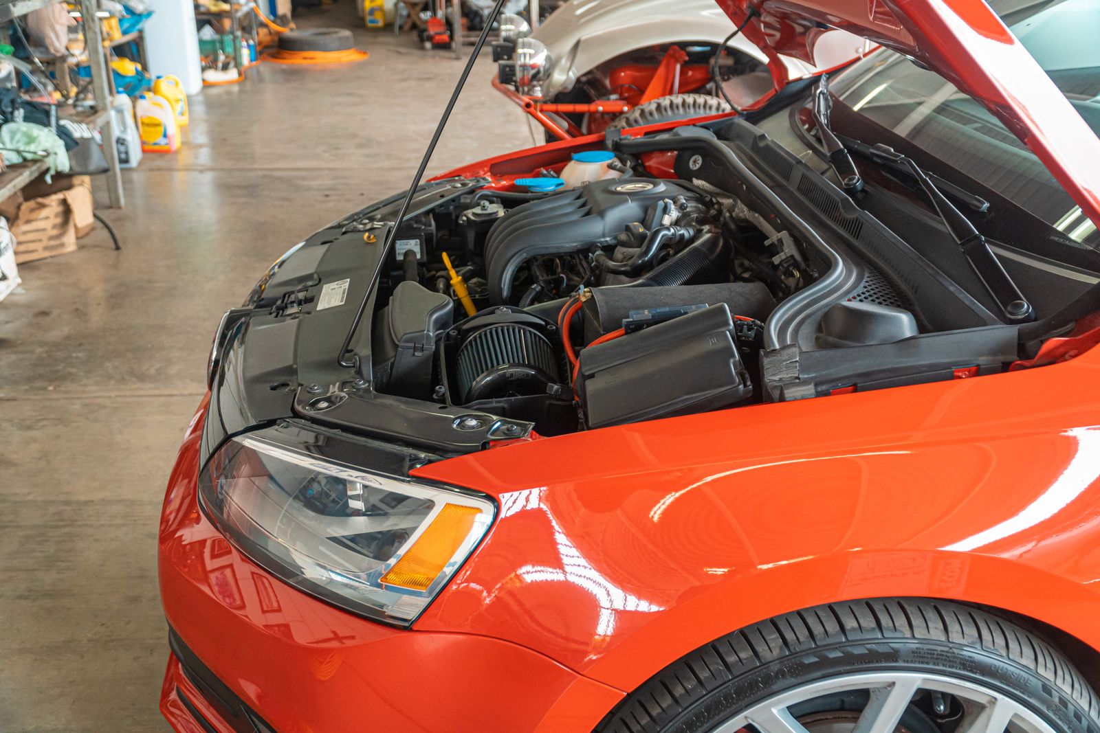 A car engine bay with the hood raised, ready for jump-starter clamps