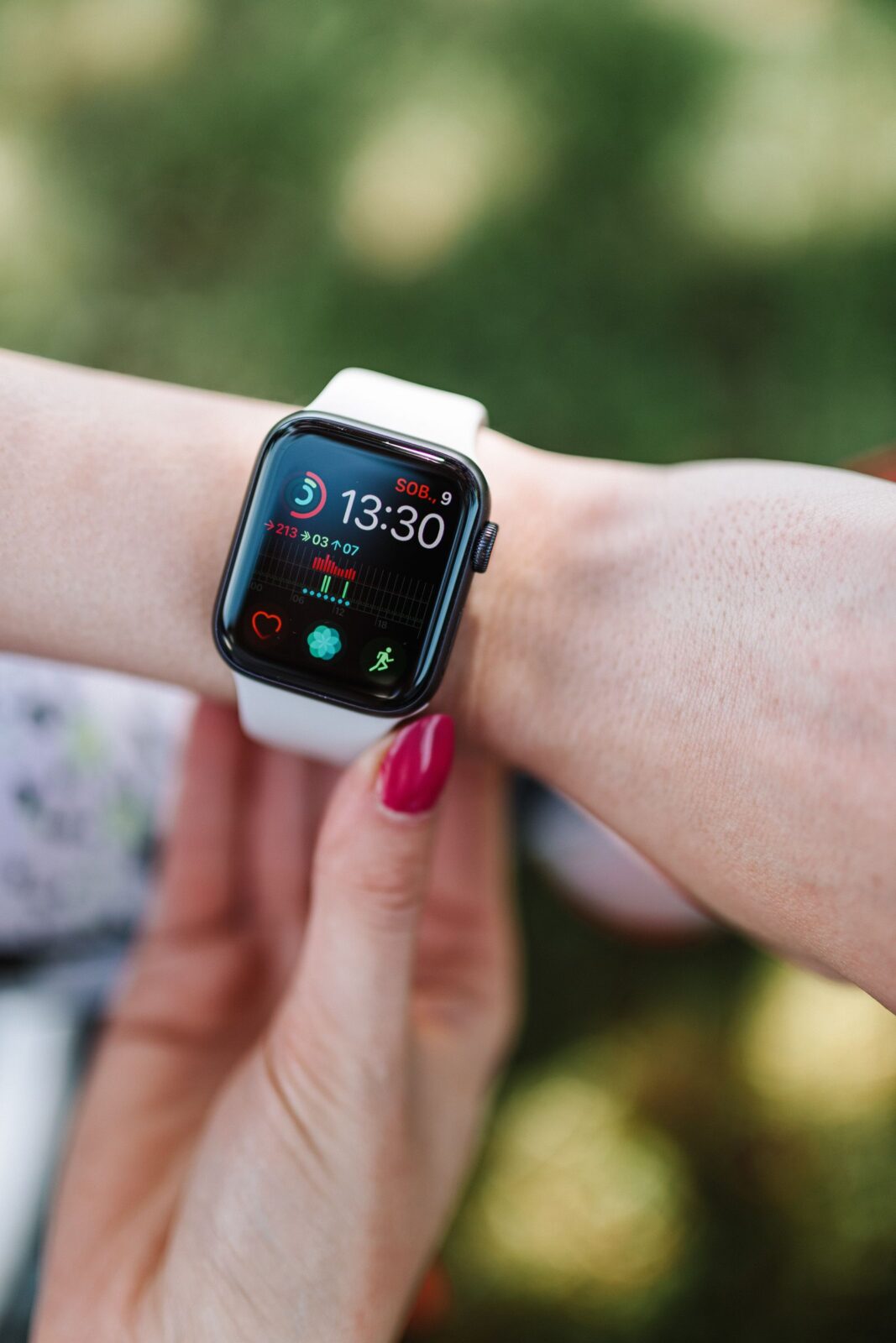 A slim fitness tracker band with a bright screen worn on a wrist in daylight