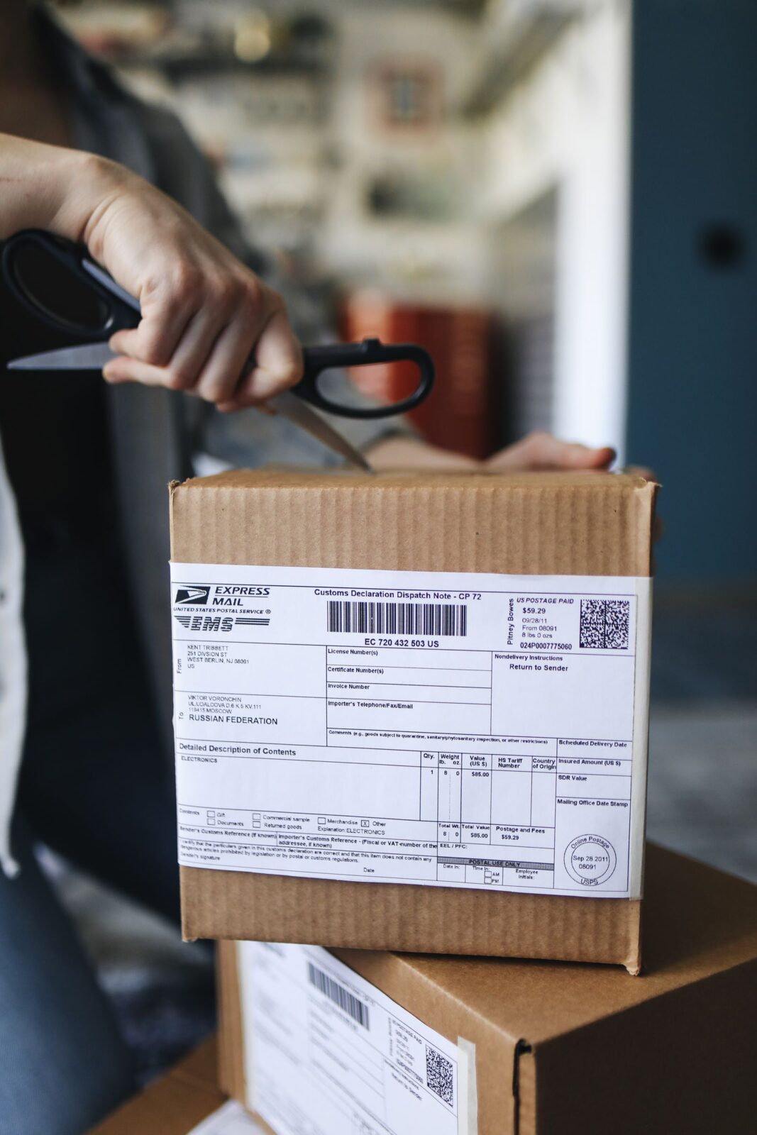 A person unboxing a discreetly packaged delivery at home