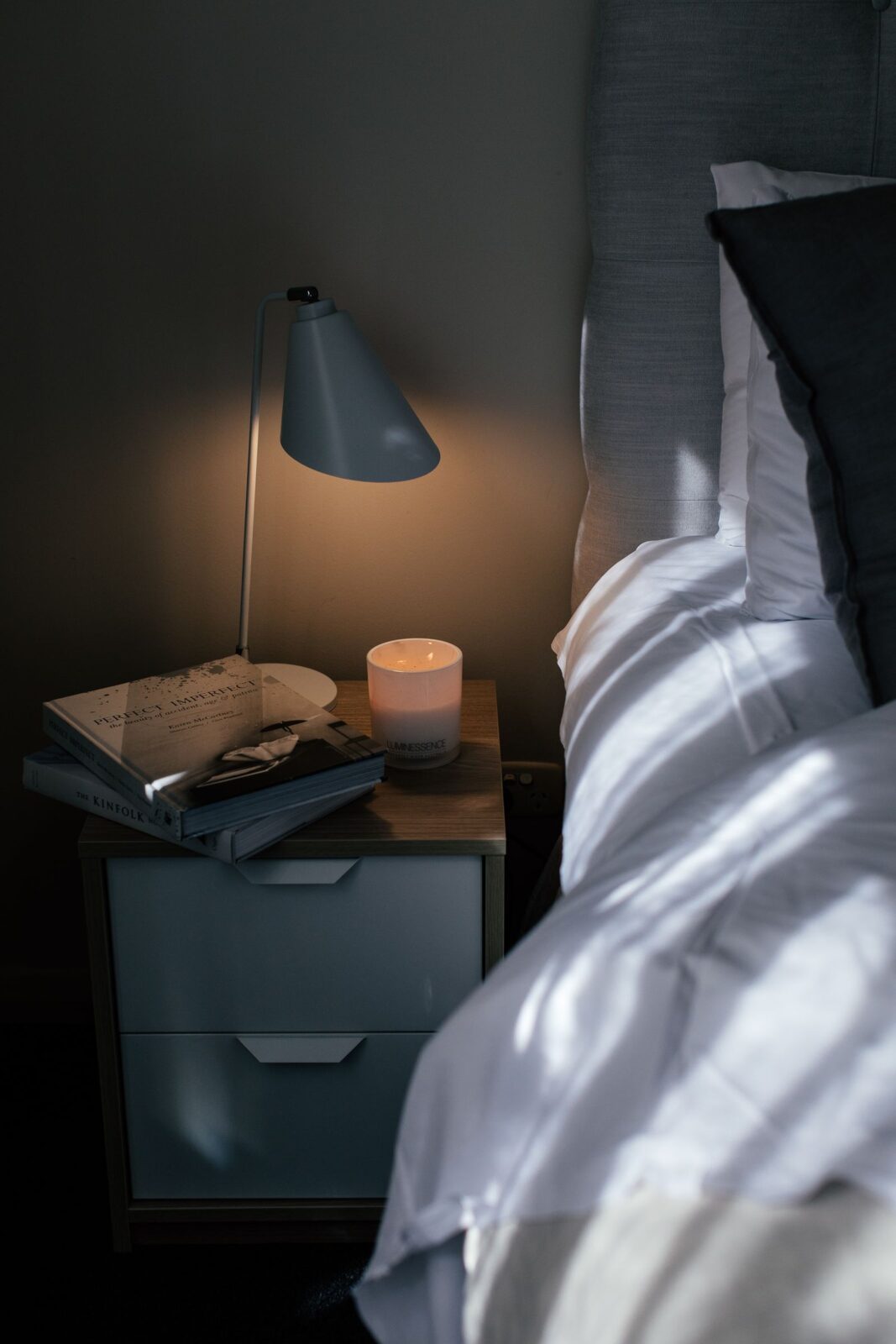 Minimalist phone-free nightstand with a bedside light device and a book