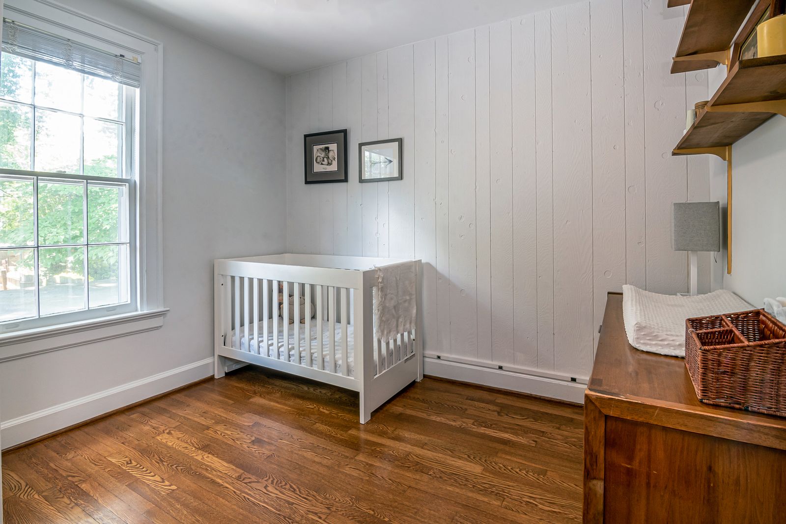 A bare crib with a firm flat mattress and fitted sheet