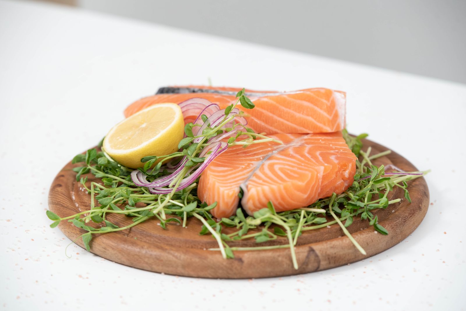 Fresh salmon and sardines with lemon on a wooden board