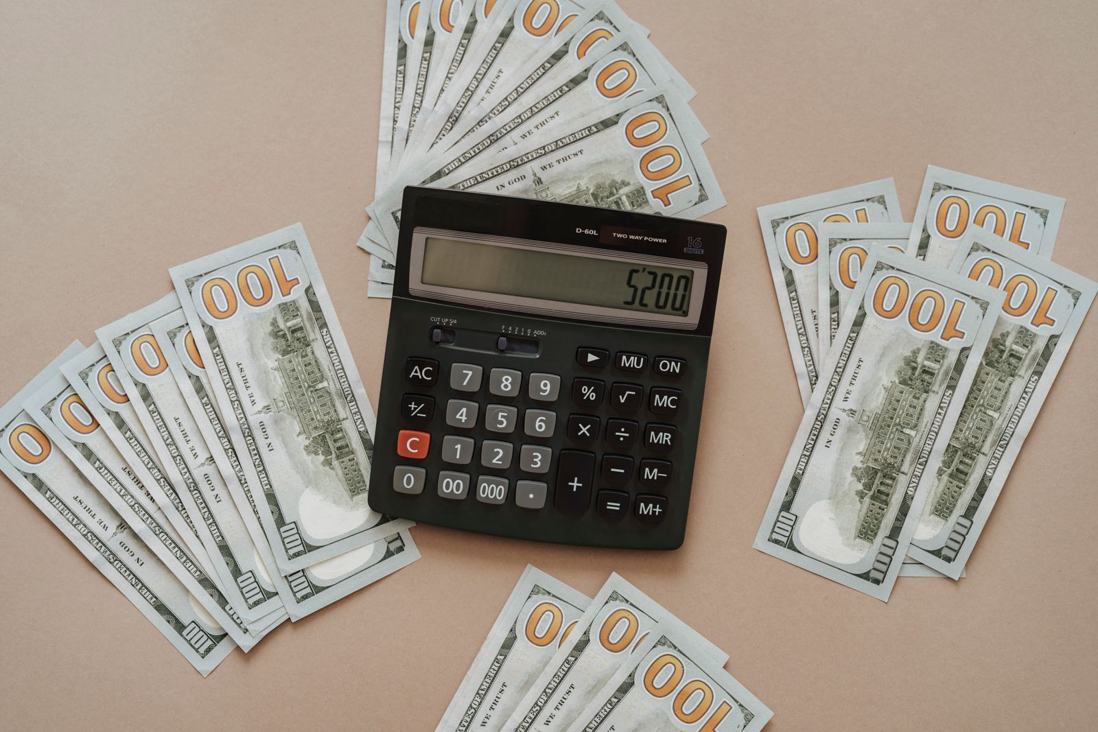 A calculator resting next to dollar bills representing medication cost comparison
