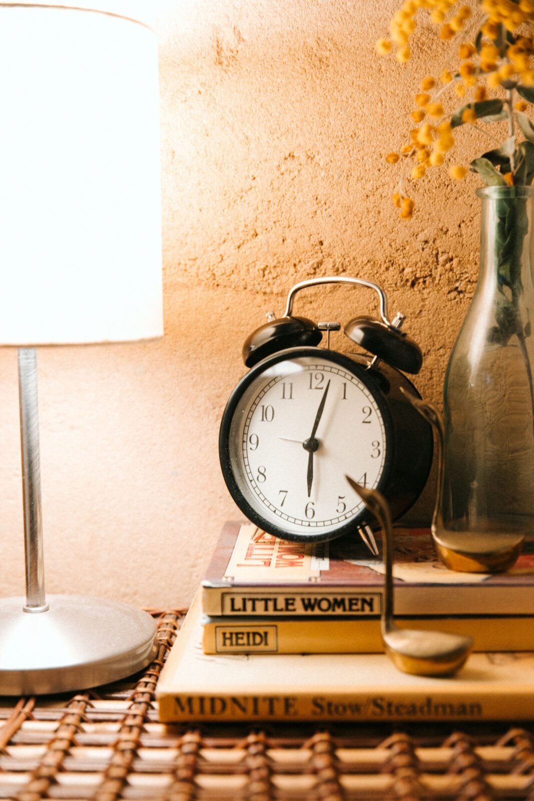 Sunrise alarm clock glowing warm amber on a bedside nightstand