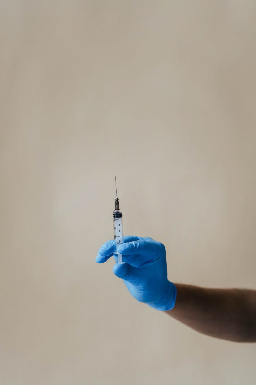 A person holding a syringe representing a weekly compounded GLP-1 injection