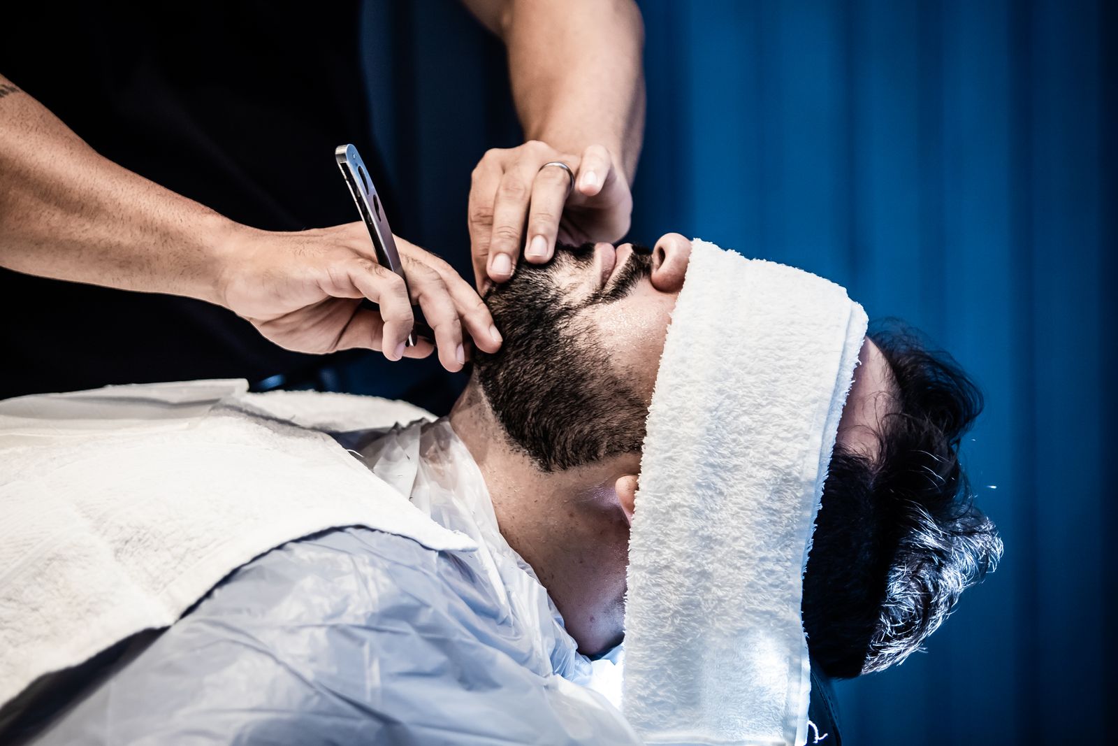 Close-up of a man's beard being trimmed with an electric trimmer