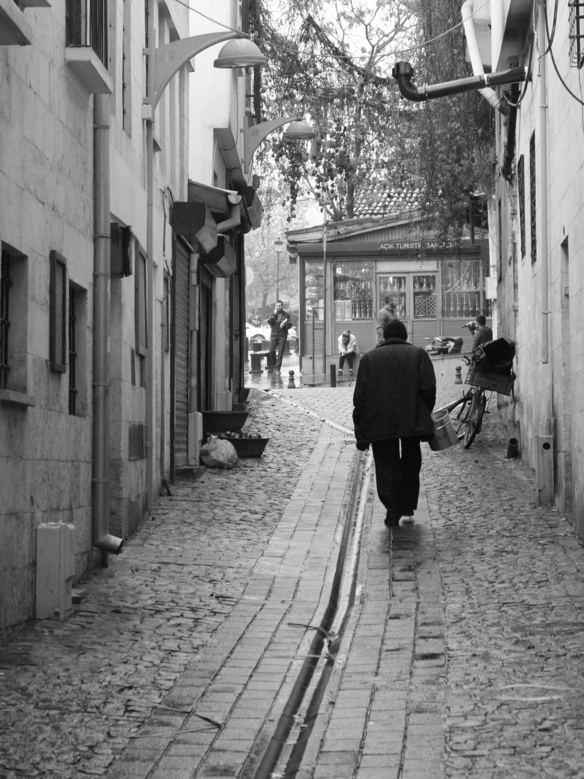 Person walking along a cobblestone street