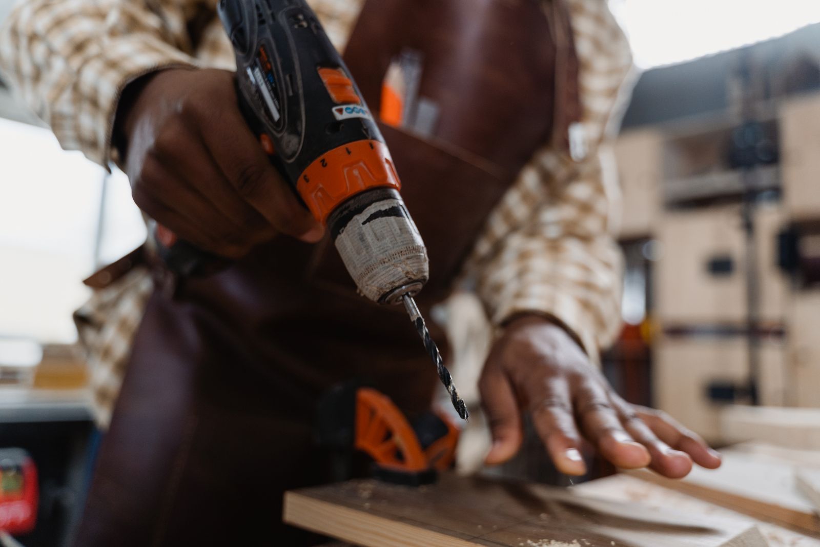 A man using a cordless power drill to drive a fastener into wood