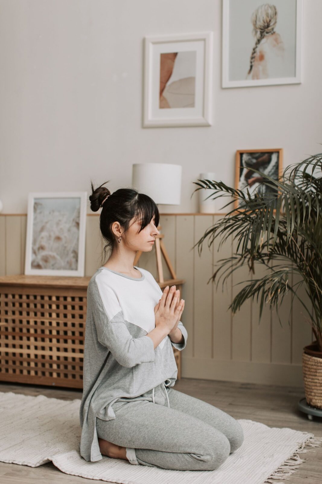 A woman sitting calmly and meditating at home