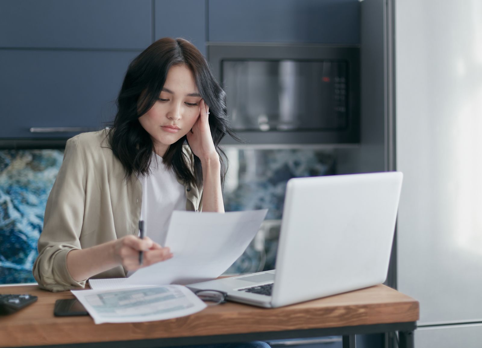 Person reviewing costs with a calculator and laptop