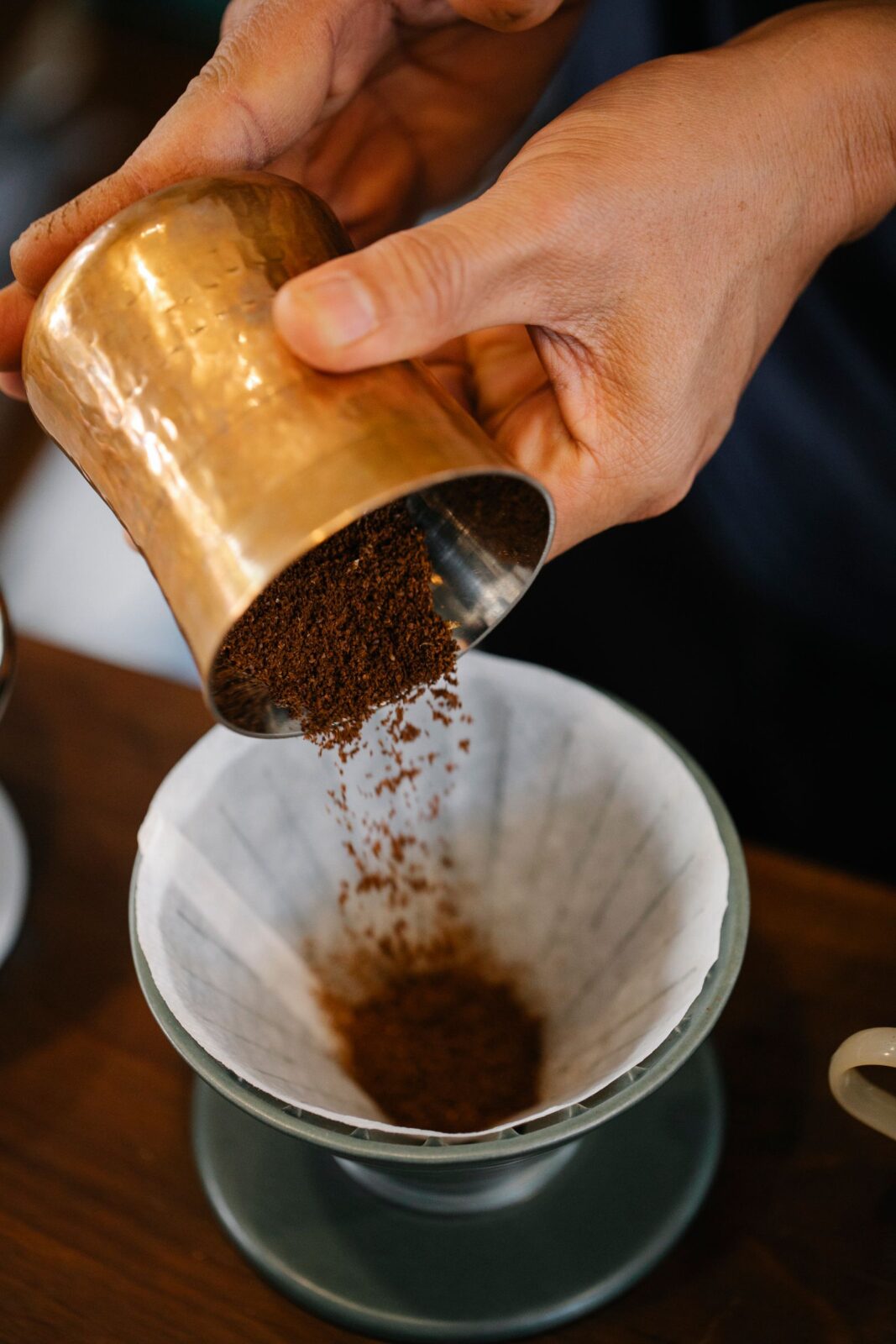 A gooseneck kettle pouring water over a pour-over dripper