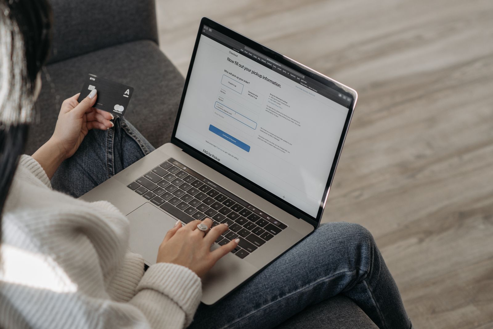 Person shopping online on a laptop while holding a credit card