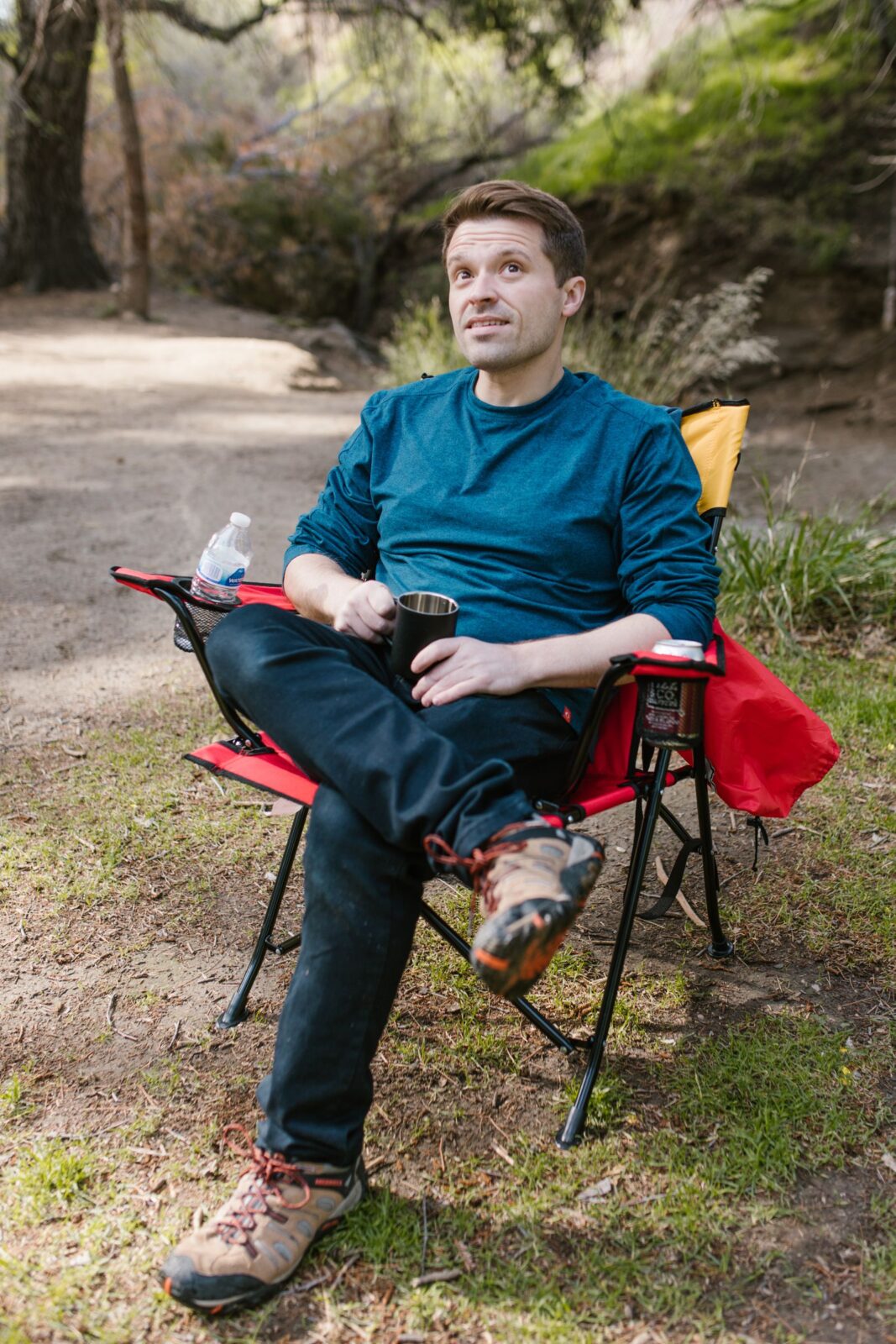 A person relaxing in a folding camping chair outdoors