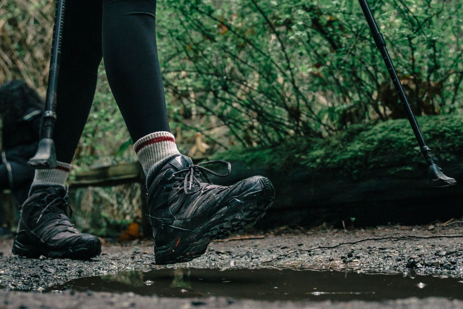 Low-angle view of a person wearing hiking boots on a rocky trail