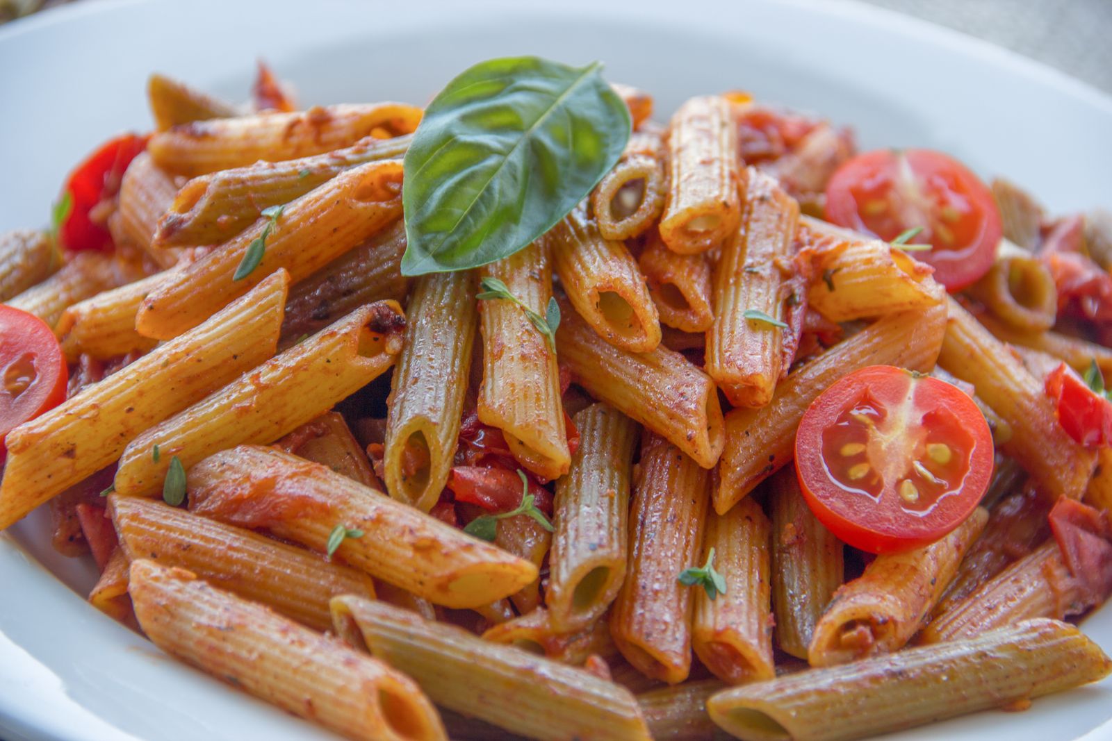 Bowl of chickpea pasta with tomato sauce and fresh basil