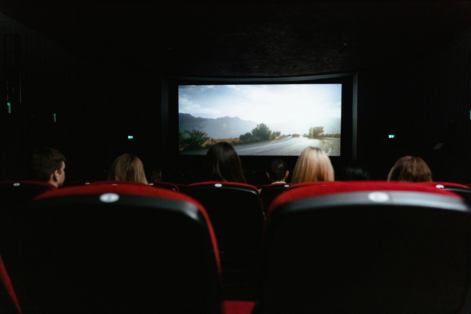 A group of people gathered watching a projected movie in the dark