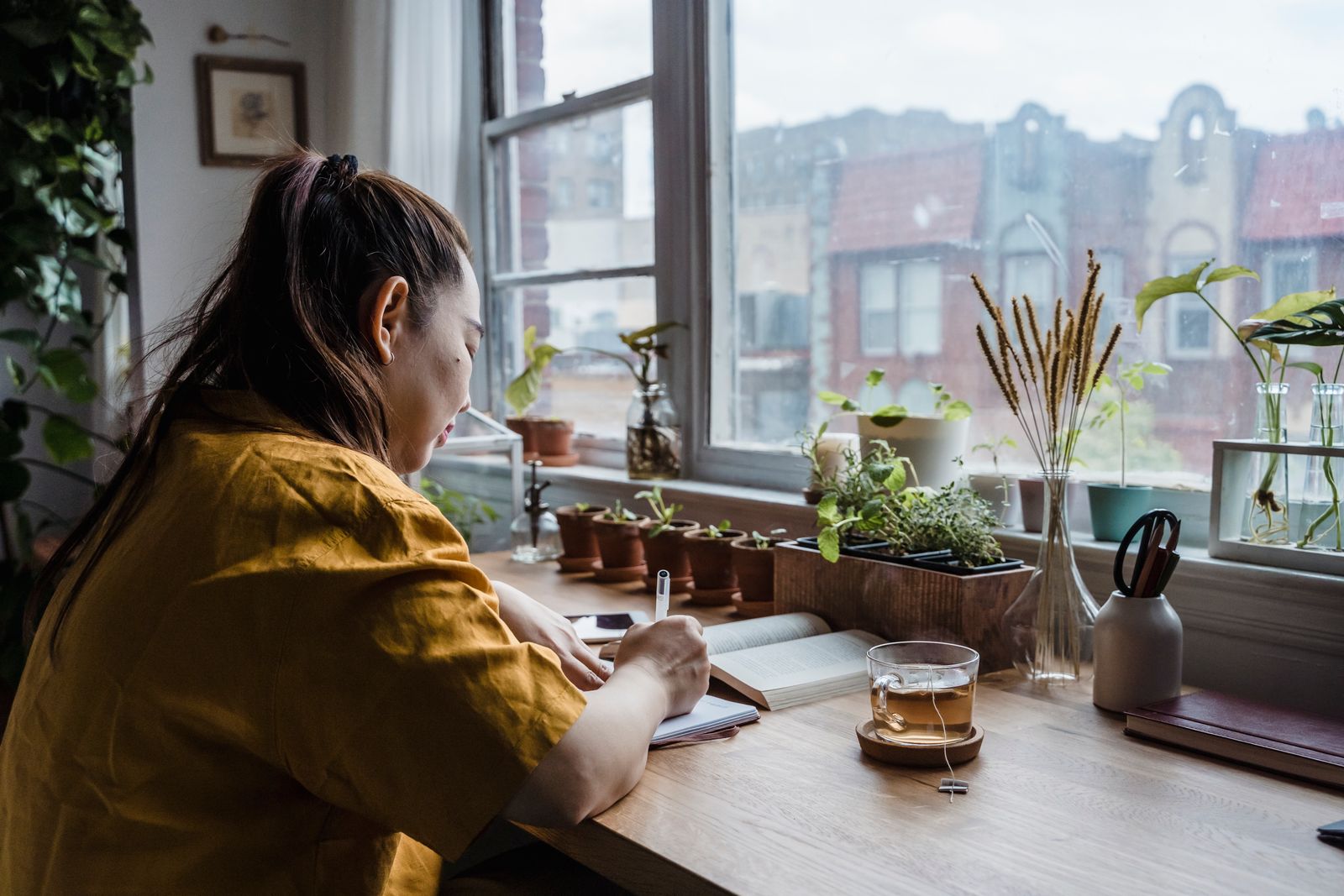 Person at a desk in the morning with a bright-light lamp beside them