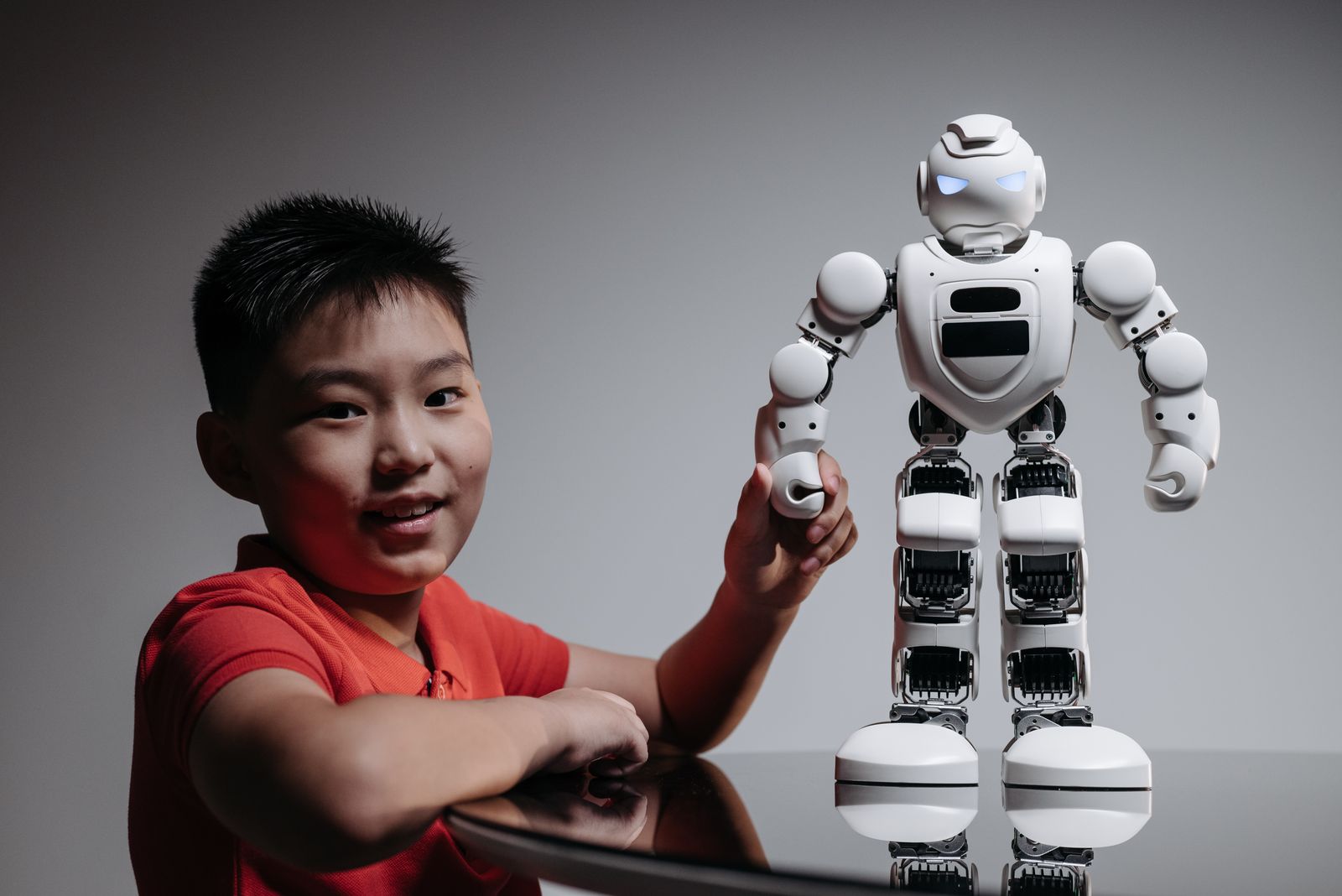 A boy holding a white toy robot