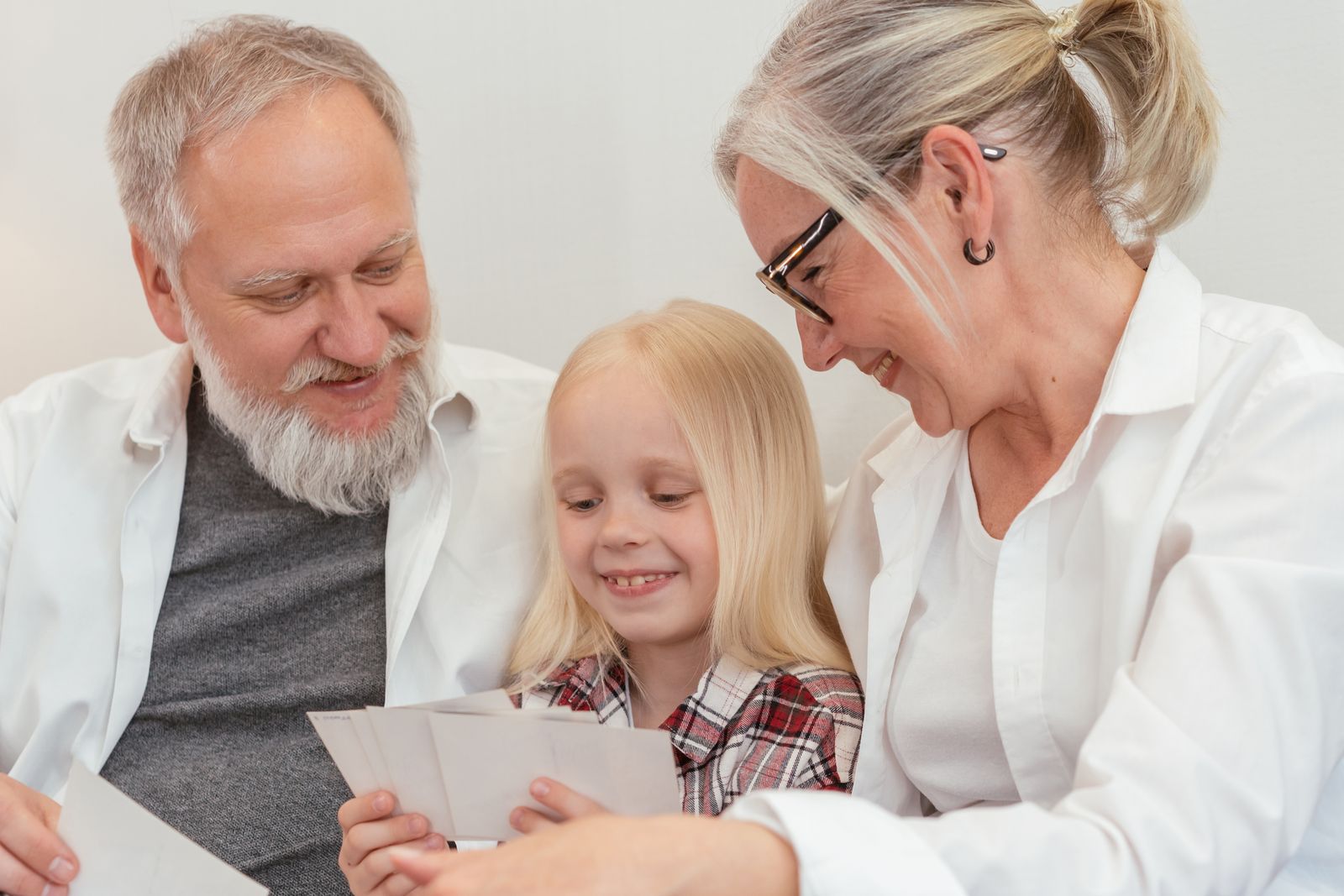 A child and her grandparents looking at family photos together