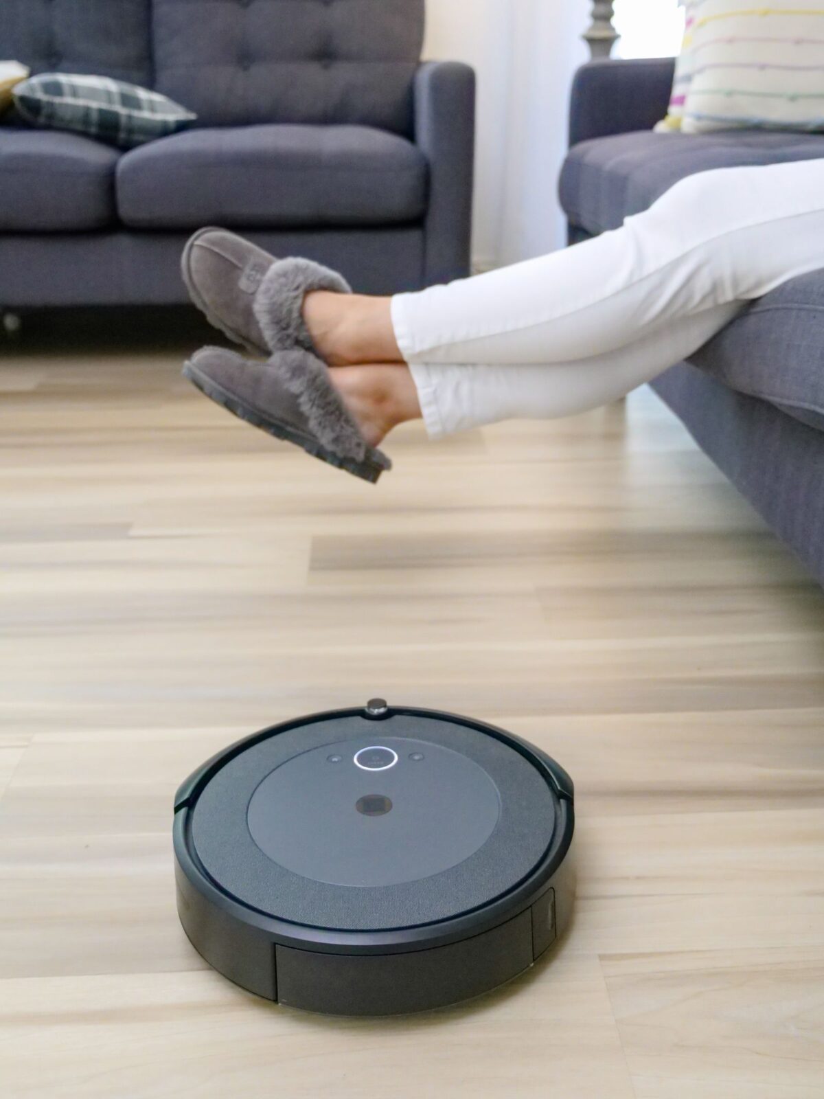 A robot vacuum cleaning a rug with a dog resting nearby