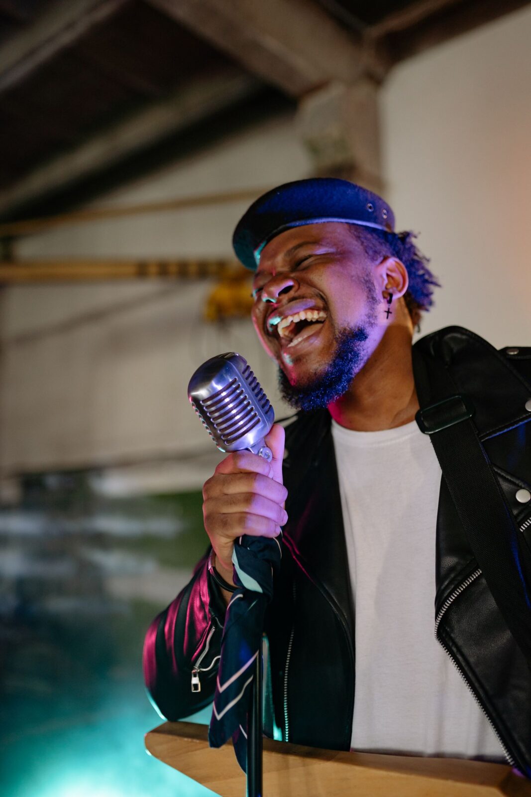 A person singing into a wireless handheld microphone at home