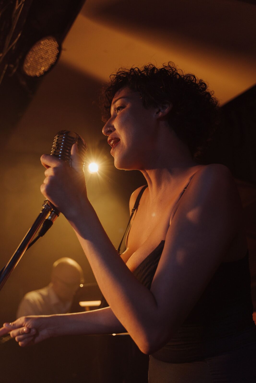 A person holding a microphone and singing along to a song