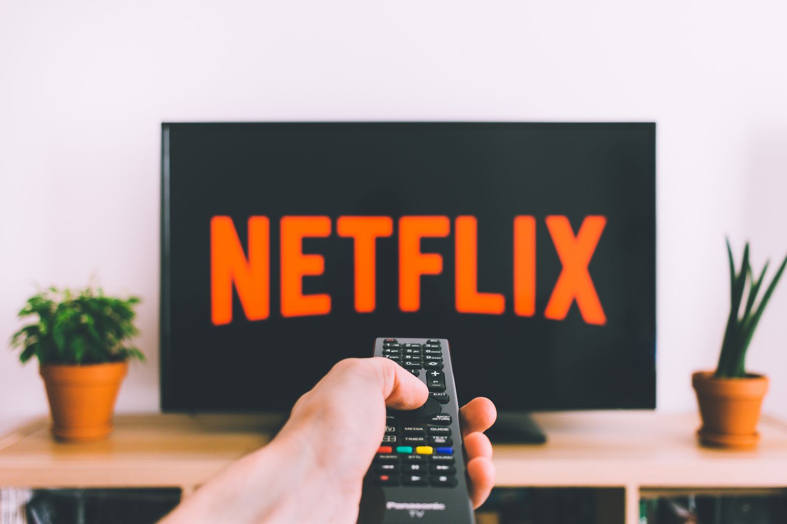 Person holding a remote control while streaming on a television