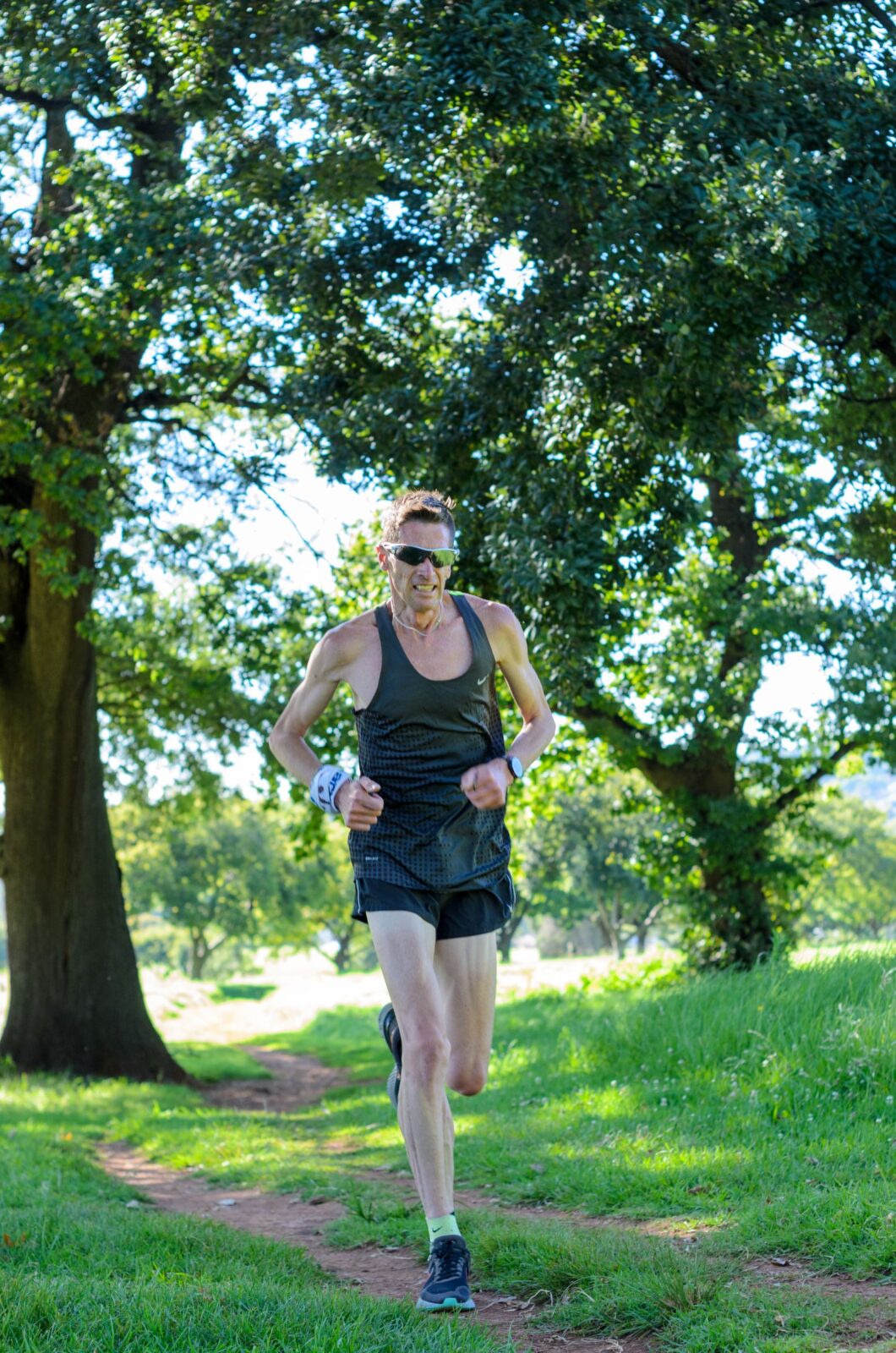 Runner on a wooded trail, the kind of GPS-heavy outdoor session that tests battery life and positioning accuracy