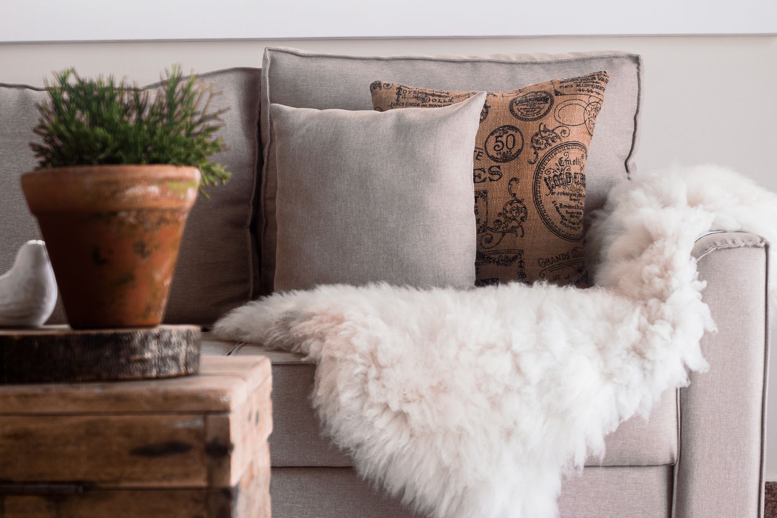 Throw pillows and a soft fur blanket draped over a couch