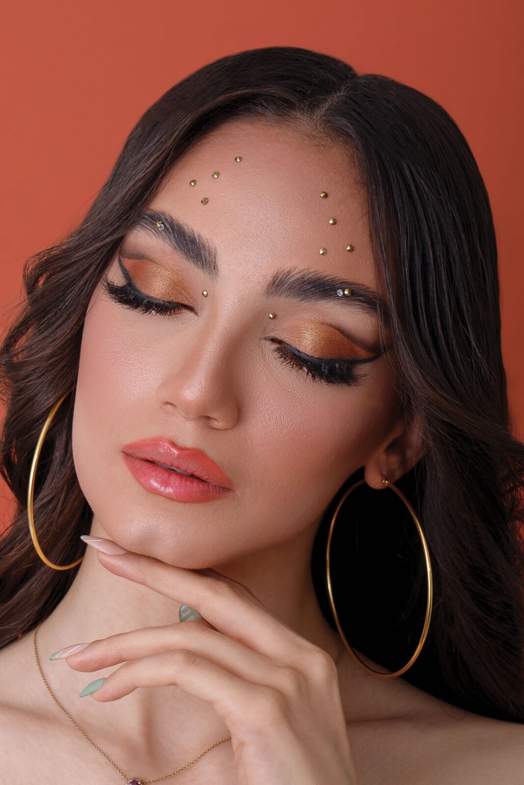 Close-up portrait showing a gold hoop earring worn on an ear