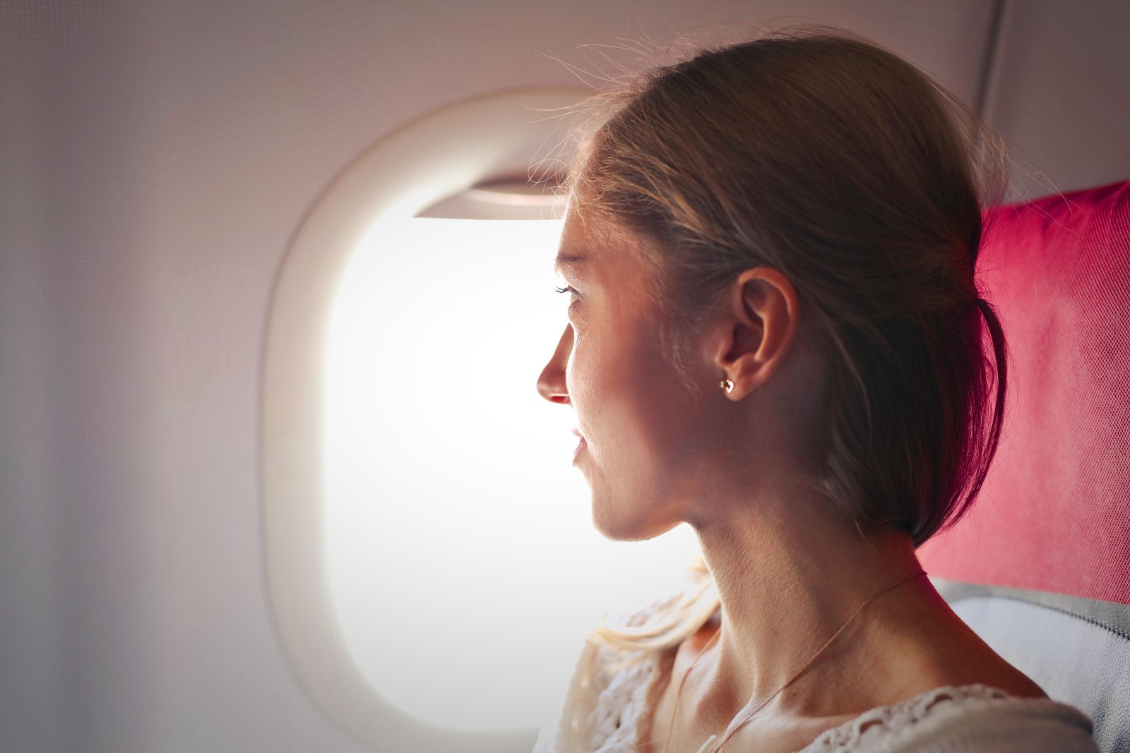Woman seated by an airplane window during a long flight