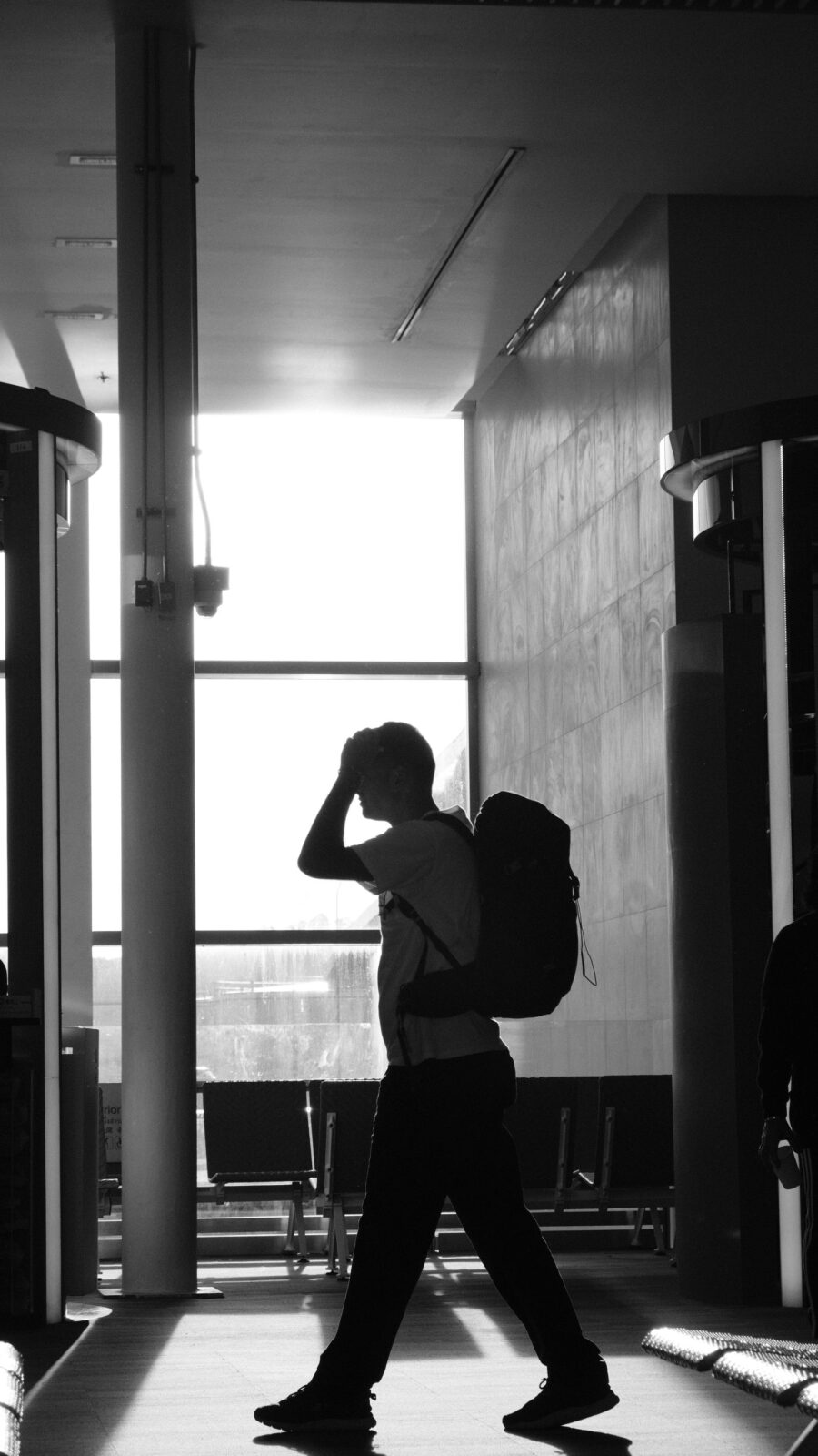 Man wearing a travel backpack while walking through an airport