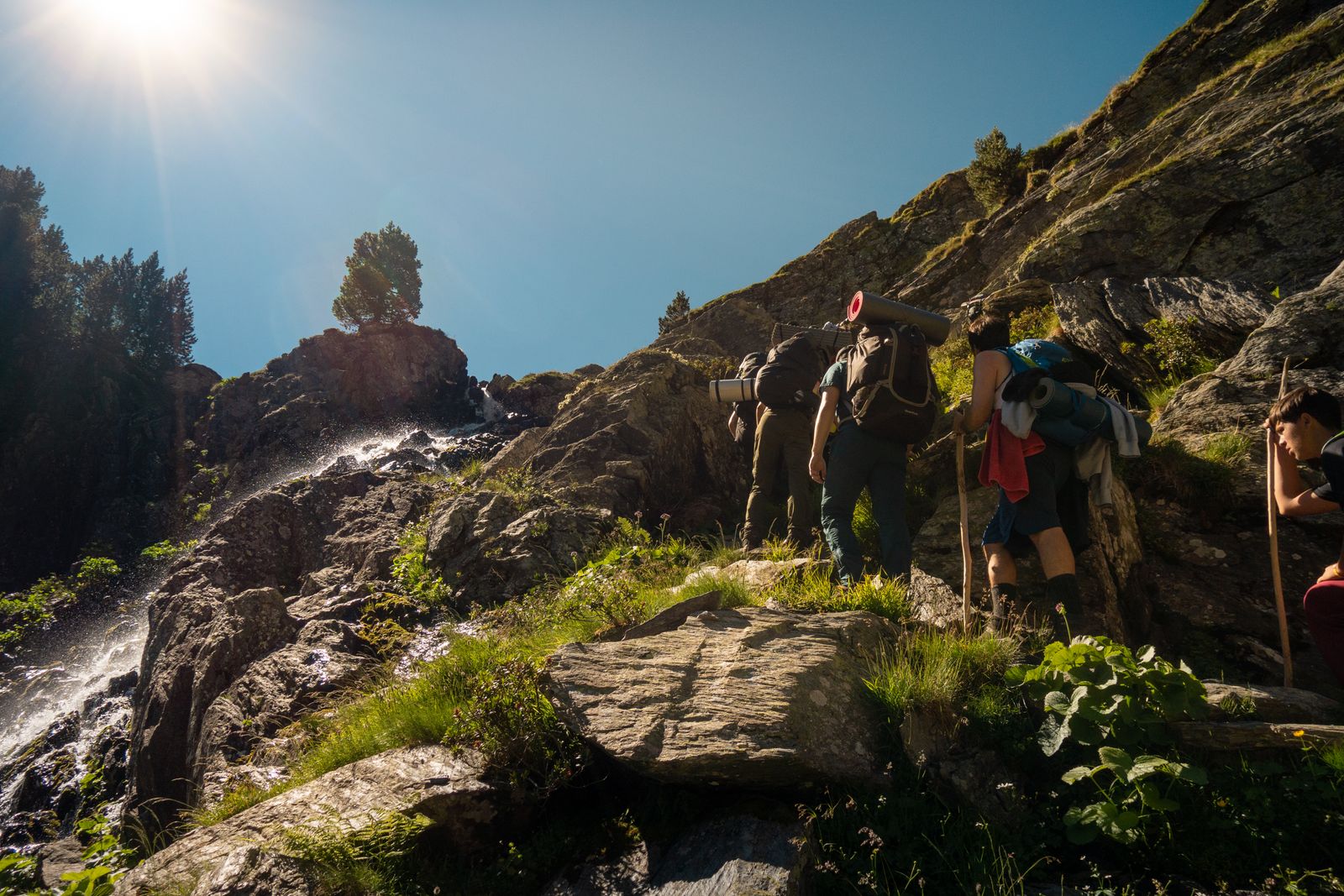 Backpackers ascending a rocky mountain trail in the Pyrenees, the steep rocky terrain that tests a GPS smartwatch's signal accuracy