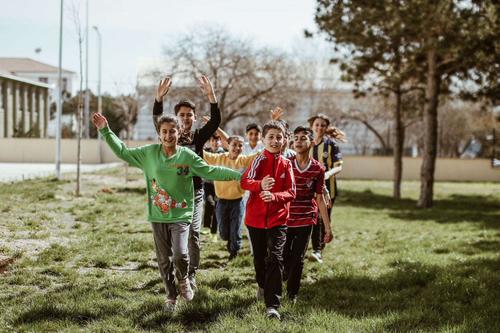 Group of children running and playing together outdoors in a garden