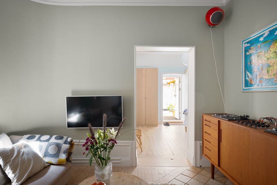 Wall-mounted television above wooden cabinetry in a mid-century modern living room