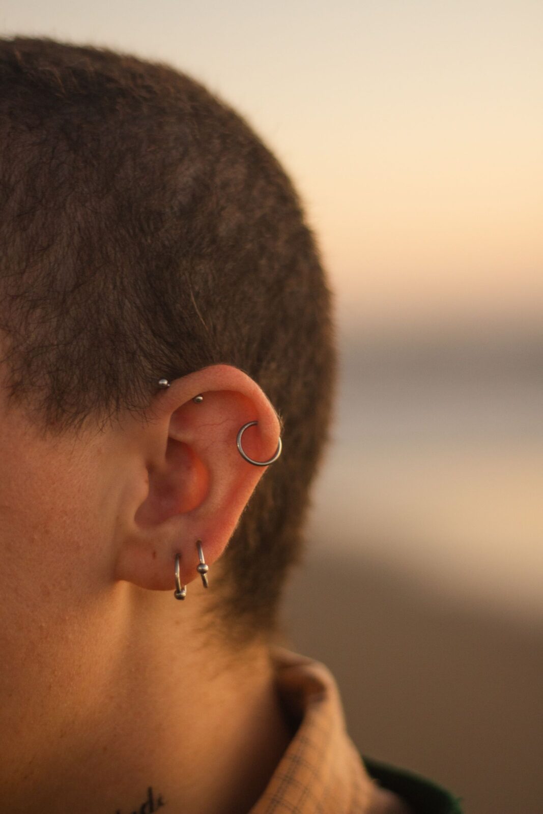 Close-up of an ear lobe showing multiple piercings, illustrating skin contact points where metal allergies develop